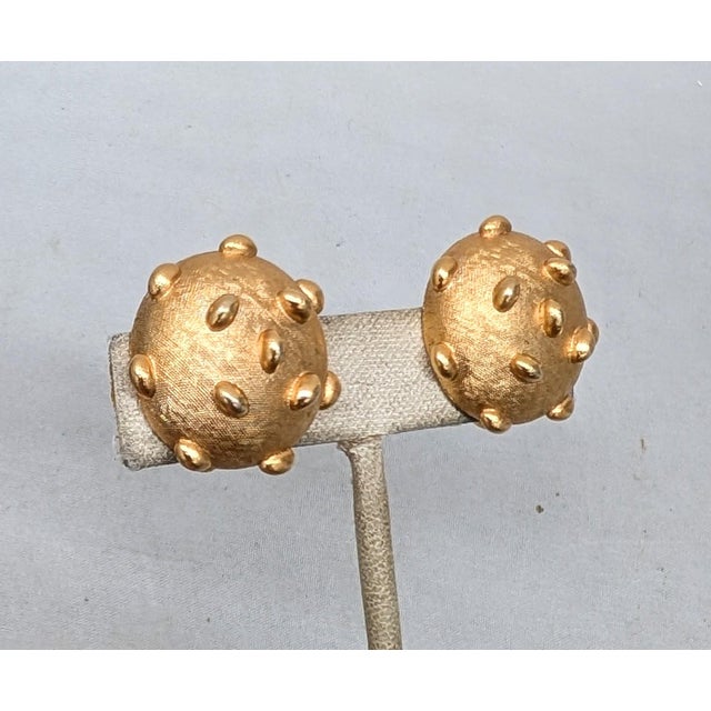 Circa late 1960s round goldtone oblong studded clip earrings. Marked crown "TRIFARI ©" on the clips. Measure: 1 inch...