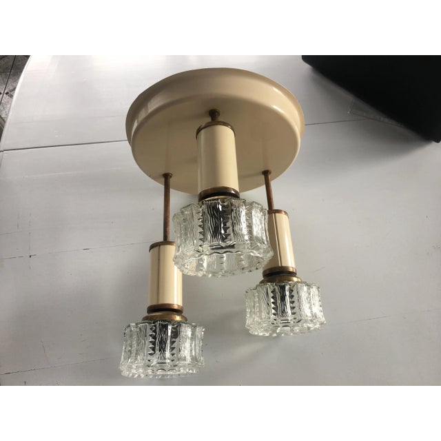 Hanging lamp with 3 light points, 1960-70 made of enamelled metal and glass. The set does not include bulbs. The photos...