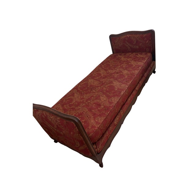 Elegant French Louis XV–style chaise lounge featuring a carved wood frame, scrolled arms, and gently shaped legs....