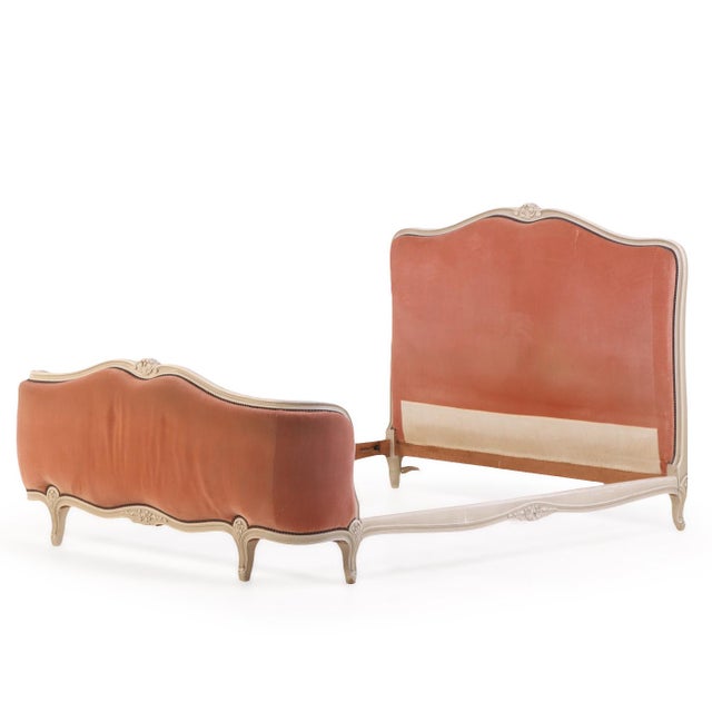 Having a gracefully shaped and molded painted wood frame with an undulating crest rail and delicate carved floral ornament...