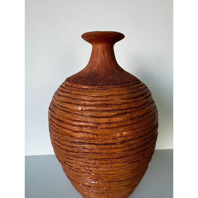 A beautifully handcrafted studio pottery bud vase featuring an organic, sculptural silhouette and richly textured surface....