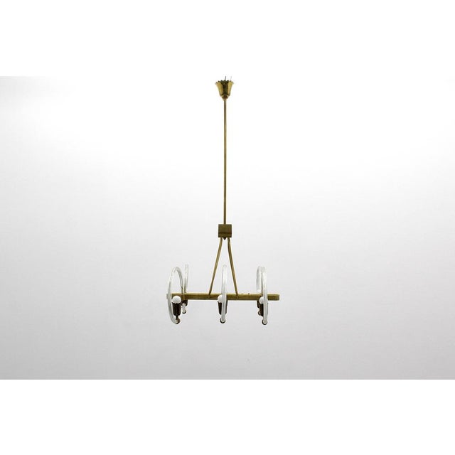 Beautiful and refined Murano glass chandelier with six circular glass arms and brass lamp holders. Gilded brass frame and...