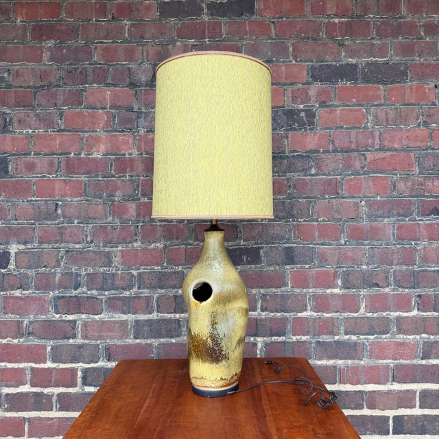 A beautiful green and brown ceramic lamp in mid-century Danish fashion. With its asymmetrical curves, unique carved holes,...