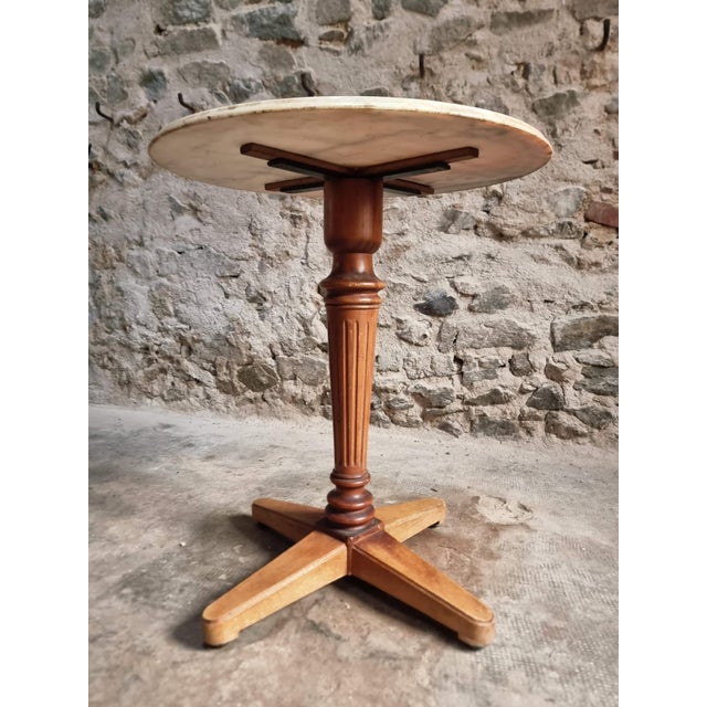 Elegant French bistro or wine table dating from approximately 1920–1940, featuring a round marble top resting on a...