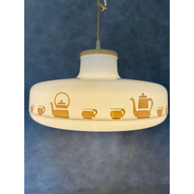 German ceiling lamp from the 1970s made of molded plastic featuring a decorative teapot and cups motif. A charming retro...