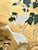 An elegant hand painted gold leaf wallpaper featuring graceful white cranes surrounded by delicate flowering branches and...