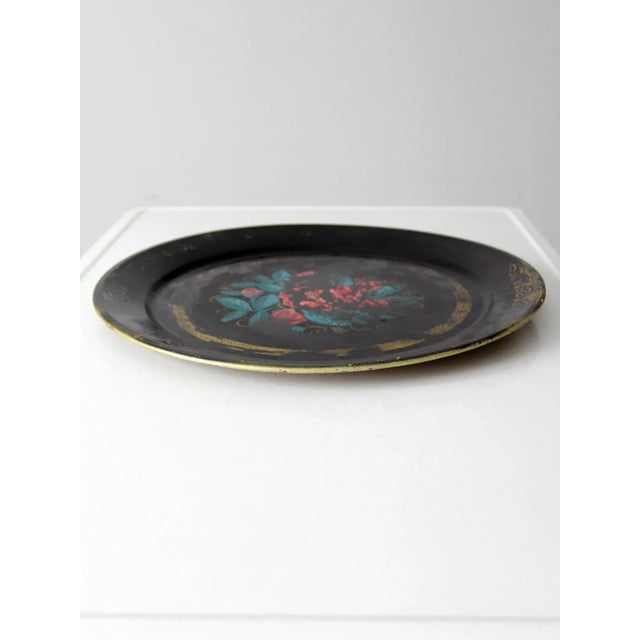 This vintage tole tray is perfect for adding a touch of charm to any home. Crafted from black metal and decorated with a...