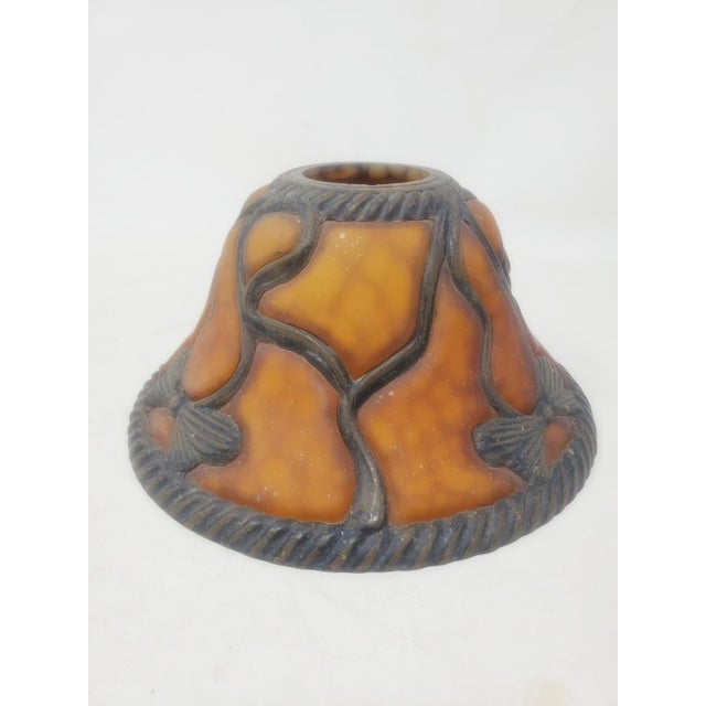 This vintage Meyda amber-color bent glass lampshade features an art deco style design with bows and ribbon accents....
