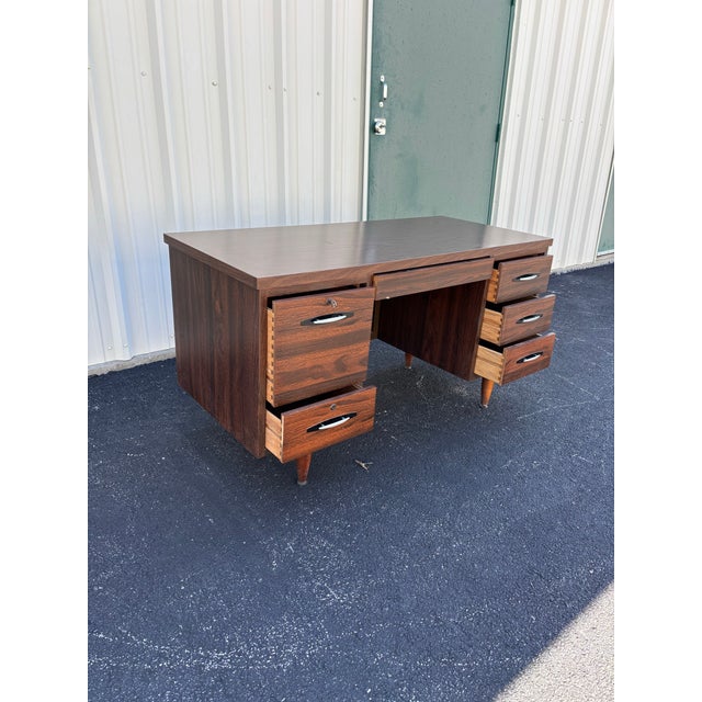 A terrific example of fine style and mid-century aesthetic. A simple shape with abundant desktop space and storage, this...