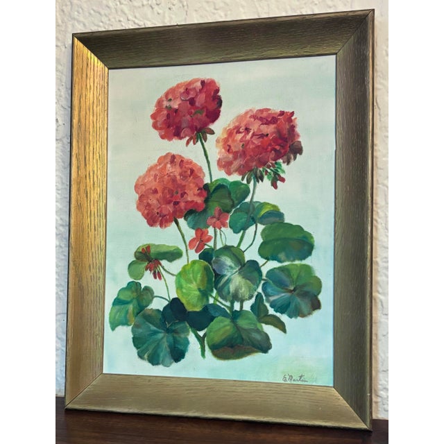 A vibrant vintage framed painting of a geranium plant with green leaves and red flowers. Framed in gold toned wood and...