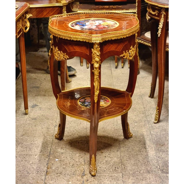 Elevate your interior with this elegant French Louis XV-style side table, crafted from richly finished wood and adorned...