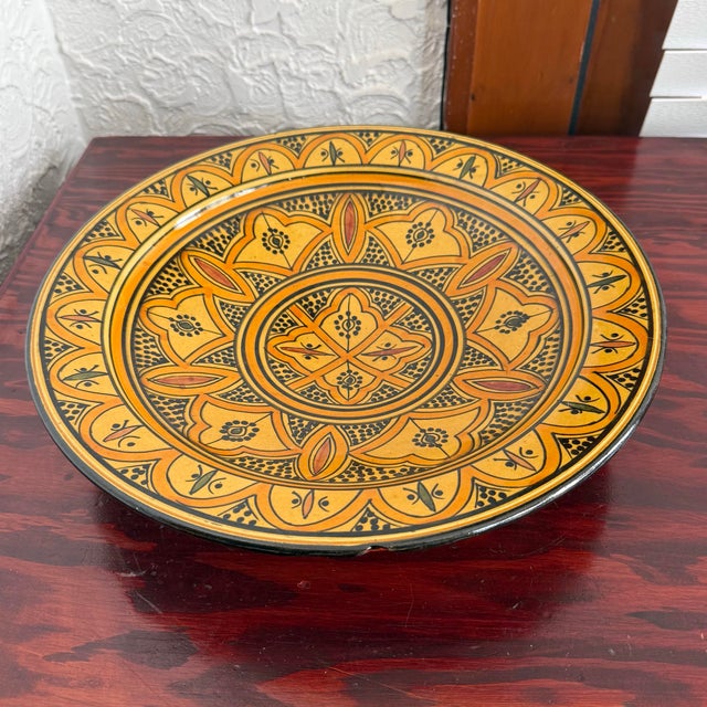 Large round hand painted shallow ceramic bowl from Morocco. The saffron yellow and orange ground is outlined and dotted in...