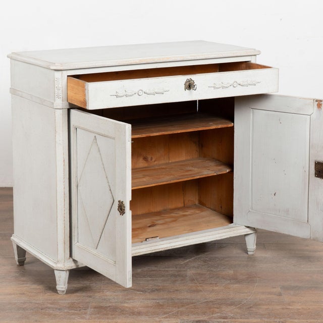 19th century Swedish sideboard, crafted in pine. The cabinet features one long drawer over two doors, giving it a simple...
