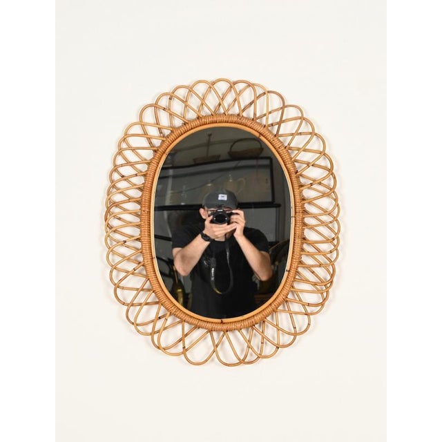 Wonderful French Riviera style large oval mirror crafted from hand-woven wicker, curved rattan, and bamboo. This stylish...