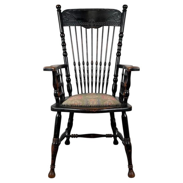 A fine 19th-century English Windsor armchair crafted from oak and finished in a distinctive ebonised surface, displaying...