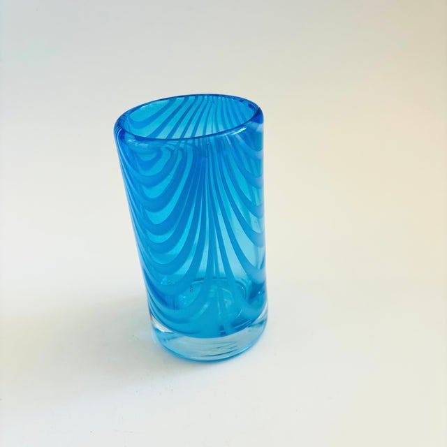 A vintage blown glass vase. Cylinder shape with a vibrant blue color to the glass. Measures 3"Dia x 5.75"H