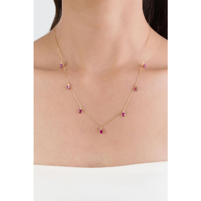This station necklace features 2.1 carats of natural emerald-cut ruby, set in 14k yellow gold. Each measuring...