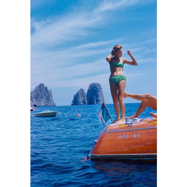 Capri Riva Boat by Toni Frissell A woman stands on the edge of a Riva boat in Capri, June 1955. (Photo by Toni Frissell)...