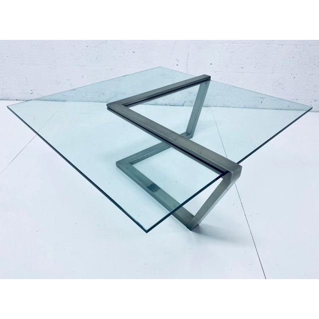 Cantilevered clear glass and brushed chrome coffee table by Design Institute of America, DIA. Signed. Glass Dimensions:...