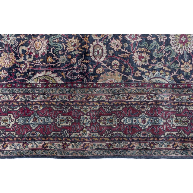 A decorative early 20th century Persian Kirman carpet, the black field with a richly colored trellis of polychrome...
