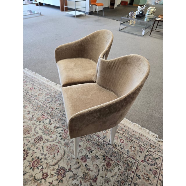 A pair of asymmetric accent chairs by Saporiti. Upholstered in a tan chenille with white legs.
