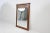 A finely crafted cherry wood wall mirror by Kindel Furniture Company, featuring a warm hand-finished frame with...