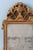 A late 18th-century French giltwood mirror in the Louis XVI style, topped by a striking crest centred on a gadrooned urn...