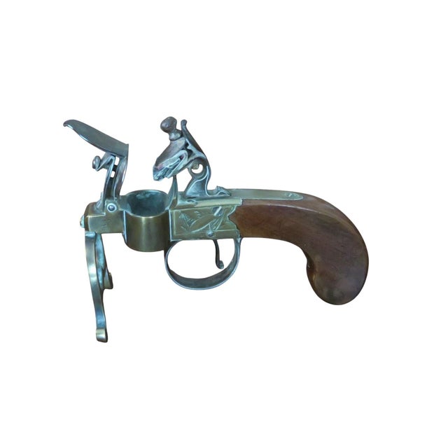 A George III Brass, Iron and Mahogany Flintlock Tinder Pistol, late 18th century. The mahogany pistol handle with brass...