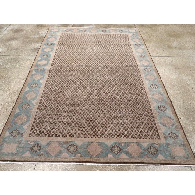 This early 20th-century Persian Serab accent rug presents a finely ordered allover pattern across a warm brown field,...