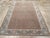 This early 20th-century Persian Serab accent rug presents a finely ordered allover pattern across a warm brown field,...