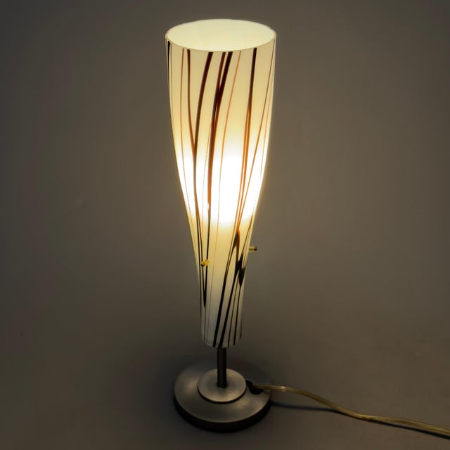 A minimalist design piece of rare elegance, perfect for stylishly illuminating desks, bedside tables, or contemporary...
