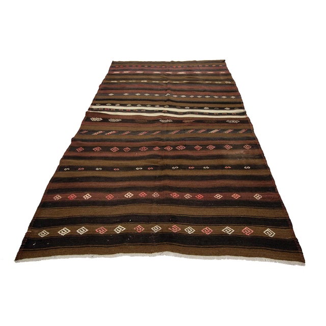 Brown handwoven vintage kilim rug from Kars region of Turkey. Approximately 50-60 years old. In very good condition