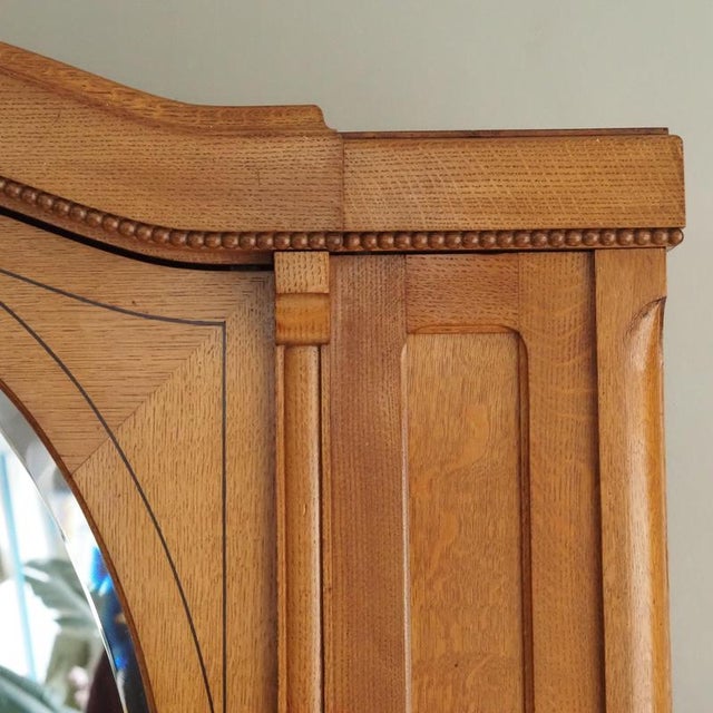 A two-door oak wardrobe with an oval bevelled mirror, stylistically situated between late Art Nouveau and reform-oriented...