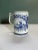 A charming mid 20th century blue and white mug featuring traditional rural scenes with a floral border.