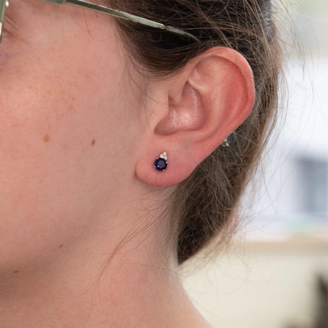 A matched pair of Ceylon blue sapphires glows in deep, velvety blue at the center of these solid 14K yellow gold stud...