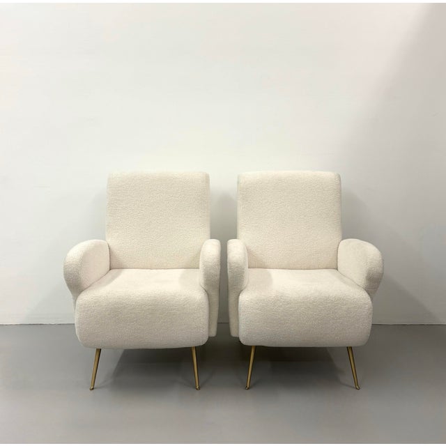 A stylish pair of vintage lounge chairs featuring softly sculpted forms newly upholstered in warm ivory bouclé. Rounded...