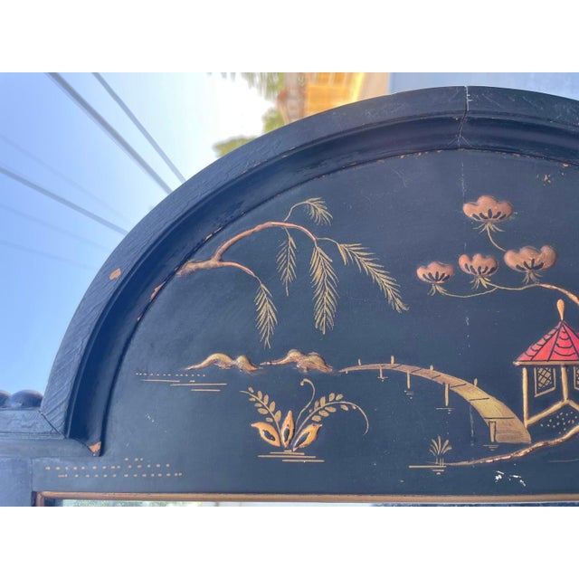 This striking vintage Chinoiserie wall mirror features a matte black painted frame with hand-gilded pagoda and willow...
