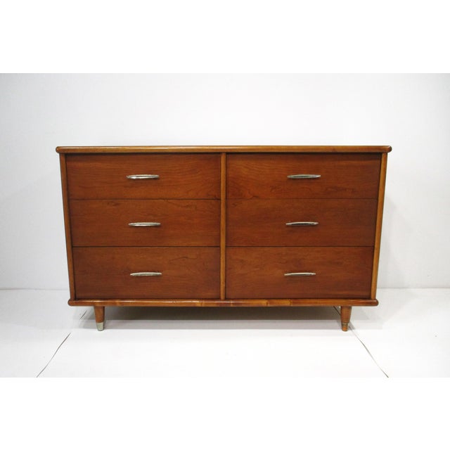 A very well crafted Mid Century six drawer dresser chest with chromed sculptural bowed pulls to each drawer front . The...