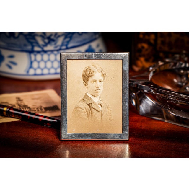 Step back in time with this elegant sterling silver picture frame, a classic keepsake from the early 1900s. With its...