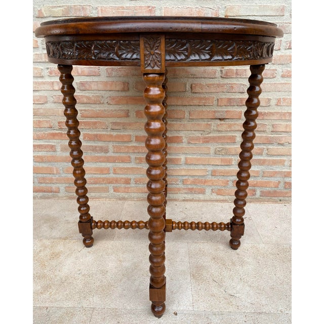 Charming Spanish round side table crafted from wood, featuring an elegant circular top and beautifully carved floral...