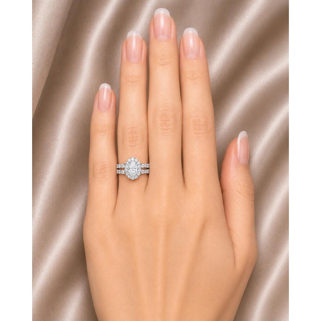 Beautiful 14K white gold engagement ring featuring a natural oval aquamarine center stone accented by brilliant round...