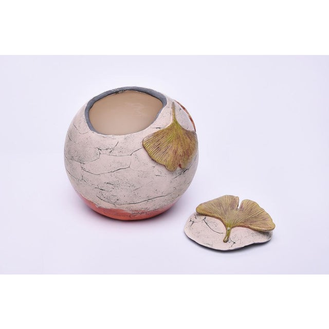 Weight: 0,7kg. Volume: 1,1 liters This round vase-like ceramic urn with ginkgo leaves is a unique piece crafted with care...