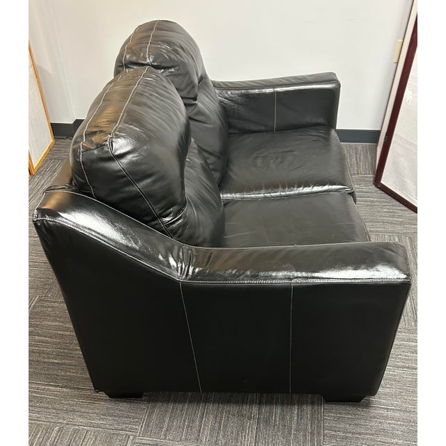 Two seat leather sofa with white stitching and cushioned backrests and seats. Transitional style, perfect size for smaller...