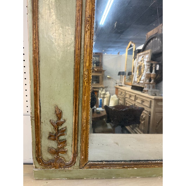 This is an Early 19th Century French Trumeau Mirror, richly embodying the elegance of the Louis XVI style. The mirror...