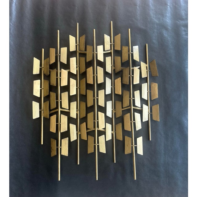Striking mid-century modern Brutalist wall sculpture crafted in brass, featuring a rhythmic arrangement of geometric...
