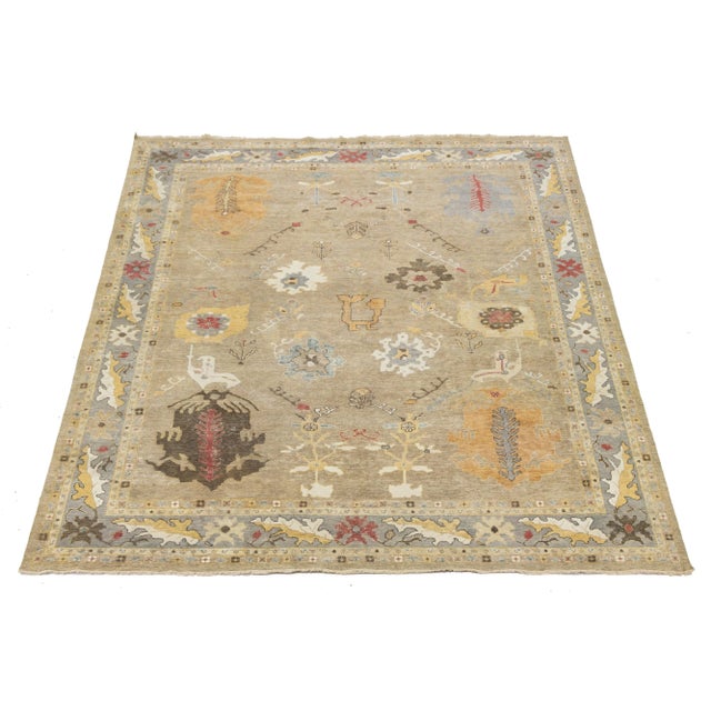 This modern hand-knotted Oushak-style wool rug beautifully merges contemporary aesthetics with the enduring charm of...