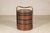 This vintage Chinese carrying basket features a cylindrical form crafted from tightly woven rattan and bamboo with a...
