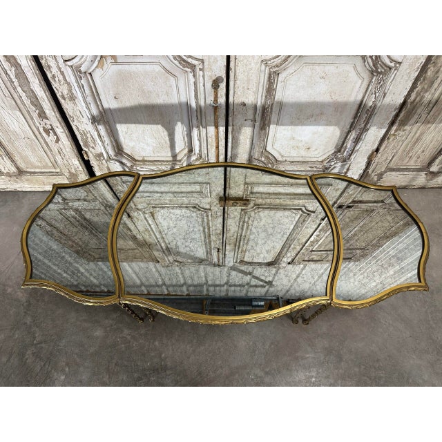 Tripartite bronze coffee table attributed to bagues or charles. Oxidized mirror-effect glass top. Scalloped edges on all...