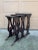 A richly layered set of three antique Regency-style nesting tables, finished in black lacquer and detailed with gilt...
