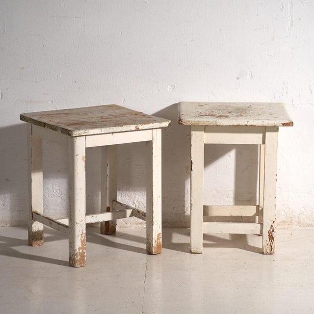 A pair of antique bedside tables in pine wood, with a square top and four tapered legs tied by box stretchers. They...